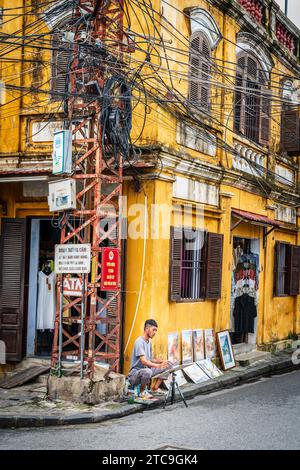 Hoi an, Vietnam, 20. November 2022: Ein Künstler arbeitet an einer Straßenecke im historischen Zentrum der Stadt Hoi an in Vietnam Stockfoto