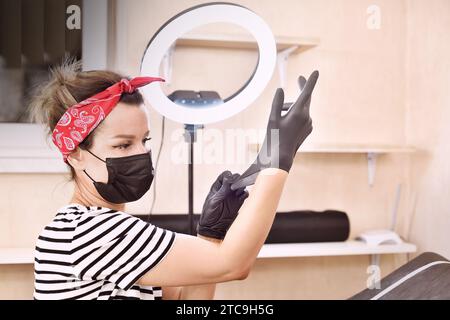 Der Tätowierer trägt schwarze Handschuhe. Kunst- und Designkonzept. Nahaufnahme Stockfoto