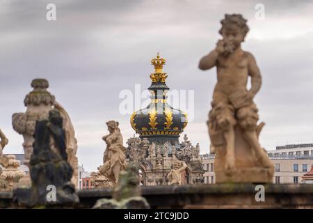 Sandsteinfiguren im Dresdener Zwinger. Der Zwinger ist ein Gebäudekomplex mit Gartenanlagen in Dresden. In der Bildmitte die goldene Krone des Kronentors. Das unter der Leitung des Architekten Matthäus Daniel Pöppelmann und des Bildhauers Balthasar Permoser errichtete Gesamtkunstwerk aus Architektur, Plastik und Malerei gehören zu den bedeutenden Bauwerken des Barocks und ist neben der Frauenkirche das bekannteste Baudenkmal Dresdens *** Sandsteinfiguren im Dresdner Zwinger der Zwinger ist ein Gebäudekomplex mit Gärten in Dresden in der Bildmitte befindet sich die goldene Krone der Krähe Stockfoto