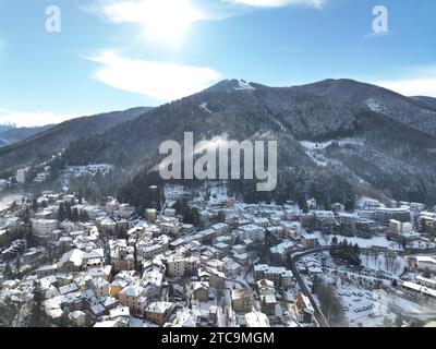Ein Blick aus der Vogelperspektive auf eine malerische schneebedeckte Stadt auf einem Hügel im Winter Stockfoto
