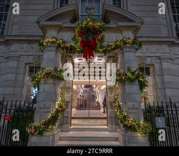 London, Großbritannien. Dezember 2023. Ein geschäftiger und trockener Abend im Zentrum von London, an dem Tausende die beeindruckende Weihnachtsdekoration in Westminster bewundern. Bild: Dekorierter Eingang zu Christies Auktionshaus in der King Street. Quelle: Malcolm Park/Alamy Live News Stockfoto