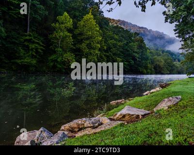 Ein malerischer Blick auf zwei Zelte am Ufer eines Flusses an einem nebeligen Tag Stockfoto