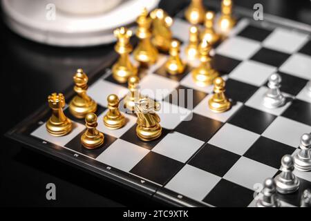 Goldene und silberne Schachfiguren auf dem Spielbrett, Nahaufnahme Stockfoto