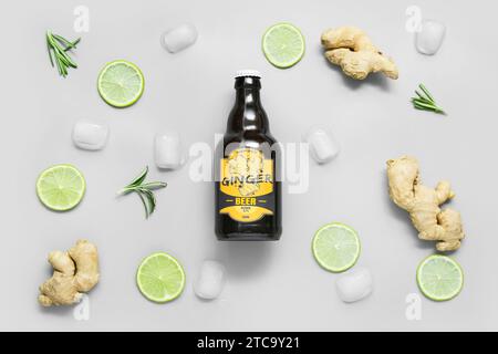 Komposition mit Flasche frisches Ingwerbier, Limettenscheiben und Eiswürfeln auf hellem Hintergrund Stockfoto