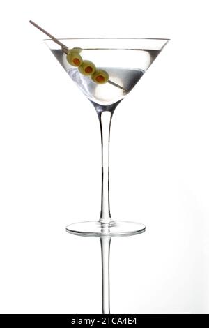 Martini-Mischgetränk mit Olive garnieren auf einem grauen Hintergrund mit Reflexion Stockfoto
