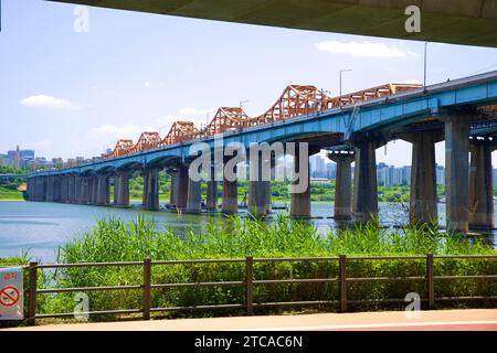 Unterhalb des Gangbyeon Expressway ragt die Dongho Bridge mit ihren orangen Böcken hervor, die elegant über den Fluss Han münden. Stockfoto