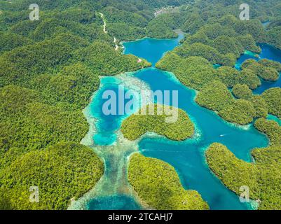 Aus der Vogelperspektive auf die Insel mit den Hügeln des Regenwaldes und azurblauem Wasser in der Lagune mit Wolken. Sohoton Cove. Bucas Grande Island. Mindanao, Philippinen. Stockfoto