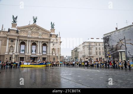 Lviv, Ukraine. Dezember 2023. Menschen mit Plakaten stehen im Zentrum von Lemberg. Verwandte und Freunde von Gefangenen des Asov-Regiments nehmen an der alles ukrainischen Aktion „sei nicht still! Töte dich! Die Ukraine wartet auf die Rückkehr ihrer Helden in die Heimat", in Lemberg, Ukraine? Sie versammelten sich, um an die gefangenen Verteidiger von Mariupol zu erinnern, die seit 19 Monaten in russischer Gefangenschaft sind und dort gefoltert werden. Gleichzeitig fand eine solche Aktion in vielen Städten der Ukraine statt. (Foto: Olena Znak/SOPA Images/SIPA USA) Credit: SIPA USA/Alamy Live News Stockfoto