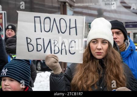 Lviv, Ukraine. Dezember 2023. Ein Demonstrant hält während der Demonstration ein Plakat mit der Aufschrift „Gefangener Tötungen“. Verwandte und Freunde von Gefangenen des Asov-Regiments nehmen an der alles ukrainischen Aktion „sei nicht still! Töte dich! Die Ukraine wartet auf die Rückkehr ihrer Helden in die Heimat", in Lemberg, Ukraine? Sie versammelten sich, um an die gefangenen Verteidiger von Mariupol zu erinnern, die seit 19 Monaten in russischer Gefangenschaft sind und dort gefoltert werden. Gleichzeitig fand eine solche Aktion in vielen Städten der Ukraine statt. Quelle: SOPA Images Limited/Alamy Live News Stockfoto