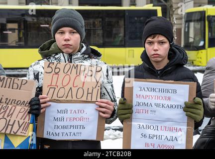 Lviv, Ukraine. Dezember 2023. Zwei kleine Jungen halten Plakate, auf denen ihre Meinung während der Demonstration zum Ausdruck gebracht wird. Verwandte und Freunde von Gefangenen des Asov-Regiments nehmen an der alles ukrainischen Aktion „sei nicht still! Töte dich! Die Ukraine wartet auf die Rückkehr ihrer Helden in die Heimat", in Lemberg, Ukraine? Sie versammelten sich, um an die gefangenen Verteidiger von Mariupol zu erinnern, die seit 19 Monaten in russischer Gefangenschaft sind und dort gefoltert werden. Gleichzeitig fand eine solche Aktion in vielen Städten der Ukraine statt. Quelle: SOPA Images Limited/Alamy Live News Stockfoto