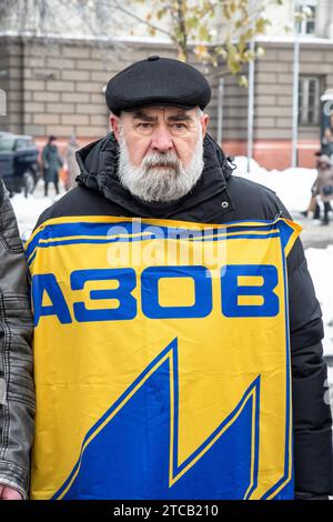 Lviv, Ukraine. Dezember 2023. Ein Mann mit der Flagge des Asow-Regiments steht im Zentrum von Lemberg. Verwandte und Freunde von Gefangenen des Asov-Regiments nehmen an der alles ukrainischen Aktion „sei nicht still! Töte dich! Die Ukraine wartet auf die Rückkehr ihrer Helden in die Heimat", in Lemberg, Ukraine? Sie versammelten sich, um an die gefangenen Verteidiger von Mariupol zu erinnern, die seit 19 Monaten in russischer Gefangenschaft sind und dort gefoltert werden. Gleichzeitig fand eine solche Aktion in vielen Städten der Ukraine statt. Quelle: SOPA Images Limited/Alamy Live News Stockfoto