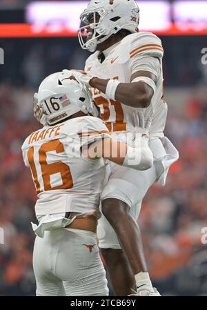 Arlington, Texas, USA. Dezember 2023. Texas Longhorns Defensive Back Michael Taaffe (16) und Texas Longhorns Defensive Back Kitan Crawford (21) feiern eine Interception während der 1. Hälfte des NCAA Football Spiels zwischen den Oklahoma State Cowboys und Texas Longhorns im AT&T Stadium in Arlington, Texas. Matthew Lynch/CSM/Alamy Live News Stockfoto