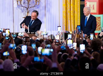 US-Präsident Joe Biden sieht zu, wie der zweite Herr Douglas Emhoff die Menora während eines Hanukkah-Feiertags-Empfangs im East Room des Weißen Hauses am Montag, 11. Dezember 2023 entzündet. Copyright: XPoolxviaxCNPx/MediaPunchx Credit: Imago/Alamy Live News Stockfoto