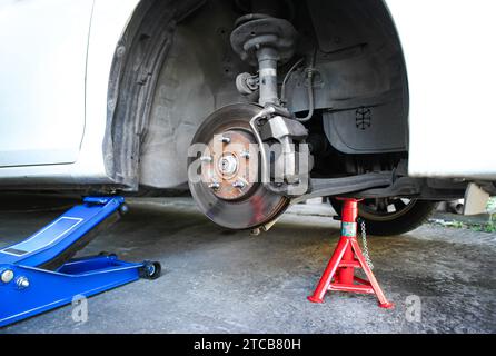 Autobremsscheiben ohne Räder , heben Sie das Fahrzeug mit dem hydraulischen Wagenheber und dem Stützbock in der Autowerkstatt an, um das Bremssystem zu reparieren Stockfoto