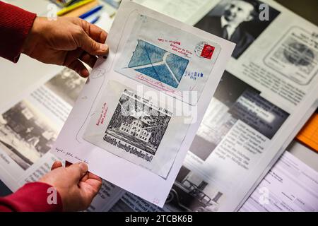 PRODUKTION - 17. November 2023, Sachsen, Falkenstein: Ralph IDE hält eine Kopie eines Umschlags aus der Zeit des Zweiten Weltkriegs vor einem Ausstellungsplakat über Alfred Roßner im Falkensteiner Stadtarchiv. Roßner, geboren in der kleinen Stadt im Vogtland, rettete während der NS-Zeit als treuhänderischer Manager einer Textilfabrik in Polen das Leben mehrerer Juden, indem er sie versteckte oder ihnen die Flucht ermöglichte. Die Gestapo erfuhr von seinen Aktivitäten und verhaftete ihn. Er starb vor 80 Jahren im Dezember 1943 im Gefängnis im heutigen Sosnowiec. Er trägt den Ehrentitel "gerecht unter den Stockfoto