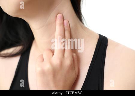 Eine Frau, die an Ösophagitis leidet, berührt ihren zerknitterten Hals. Stockfoto