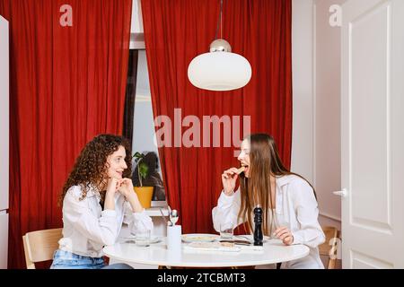 Frau erzählt ihrem Freund von gesundem Essen, das zu Hause leicht zu kochen ist Stockfoto