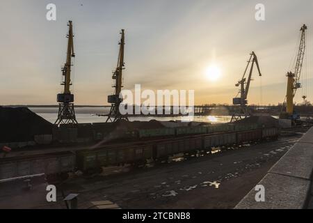 Vyborg, Russland - 15. April 2023: Hafen von Vyborg, Blick auf den Kohleterminal mit Silhouetten von Portalkranen am Abend Stockfoto