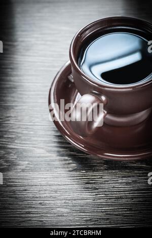 Keramikbecher mit starker Kaffeeuntertasse auf Holzbrett Stockfoto