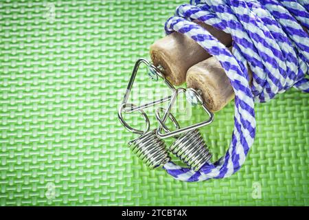 Seilspringen mit Holzgriffen auf grüner Oberfläche Fitnesskonzept Stockfoto