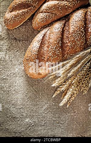 Knusprige Brotstangen Weizenohren auf hessischem Hintergrund Stockfoto