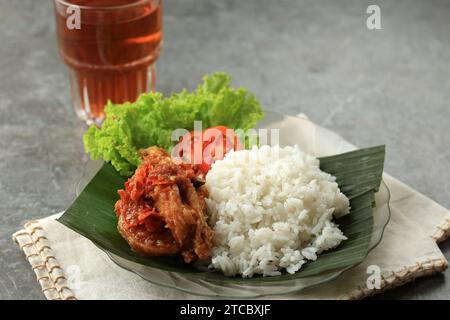 Nasi Ayam Penyet, indonesisches würziges Huhn mit verschiedenen frischen Gemüsesorten und gedämpftem Reis Stockfoto