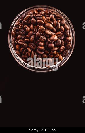 Kaffeebohnen im Glas stehen auf schwarzem Hintergrund. Ansicht vom oberen Kopierbereich Stockfoto