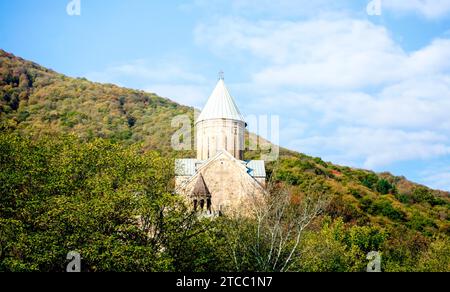 Alte antike christliche Kirche mit Kuppel und Kreuz auf einem Berg in einem Wald in Tiflis Georgien vor blauem Himmel und Wolken Stockfoto