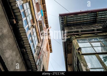 Fenster und Dächer alter Häuser vor dem blauen Himmel in der Stadt Tiflis Georgien Stockfoto