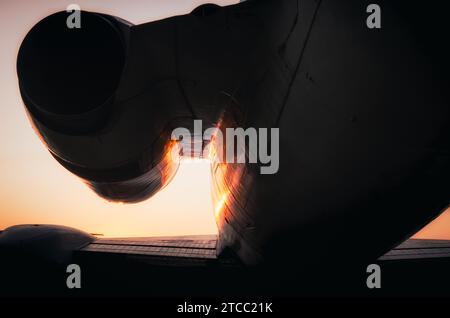 Silhouette Fragment Turbine und Flügel eines großen Flugzeugs auf Sonnenuntergang Hintergrund Stockfoto