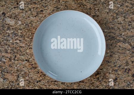 Blaue leere Platte auf strukturierter Marmorstruktur, Ansicht von oben Stockfoto