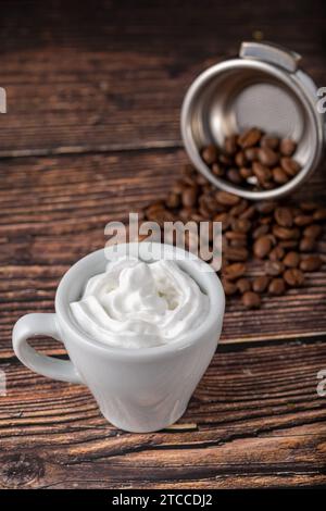 Espresso con Panna in weißer Porzellanschale auf Holztisch Stockfoto