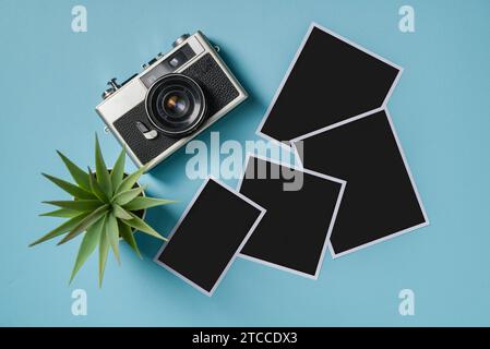 Vintage-Fotokamera und leere Bilderrahmen auf blauem Hintergrund. Fahrmoment-Konzept Stockfoto