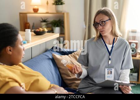 Krankenschwester verschreibt Vitamine für schwangere Frauen während ihres Hausbesuchs Stockfoto