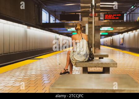 Eine Frau allein sitzt auf einer Bank und wartet auf eine U-Bahn in San Francisco, USA Stockfoto