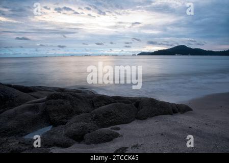 Langsame Aufnahmen der Meereswellen entlang des felsigen Strandes. Stockfoto