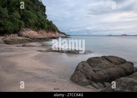 Langsame Aufnahmen der Meereswellen entlang des felsigen Strandes. Stockfoto