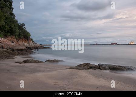 Langsame Aufnahmen der Meereswellen entlang des felsigen Strandes. Stockfoto