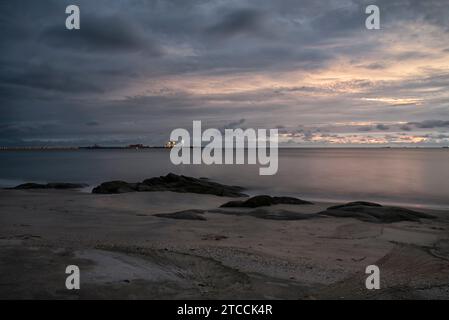 Langsame Aufnahmen der Meereswellen entlang des felsigen Strandes. Stockfoto