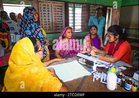 Nabin Nagar, ein Dorf an der Grenze zwischen Indien und Bangladesch, ist schlecht verbunden und isoliert von der Hauptstadt Tehatta, Indien. Deshalb wurde von der Regierung des Bundesstaates Westbengalen ein Lager eingerichtet, in dem die Dorfbewohner Medikamente verteilen konnten, nachdem sie Aadhaar-Karten durch einen medizinischen Offizier gezeigt hatten und mit Hilfe von asha-Arbeitern kostenlose Untersuchungen zur Blutdruckkontrolle an der Nabin Nagar-Grundschule durchgeführt hatten. An diesem Tag kommen alle armen Dorfbewohner, von den Ältesten bis zu den Schülern, zu einer kostenlosen medizinischen Untersuchung in Nabin Nagar, Westbengalen, Indien. Stockfoto