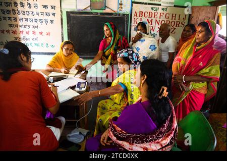 Nabin Nagar, ein Dorf an der Grenze zwischen Indien und Bangladesch, ist schlecht verbunden und isoliert von der Hauptstadt Tehatta, Indien. Deshalb wurde von der Regierung des Bundesstaates Westbengalen ein Lager eingerichtet, in dem die Dorfbewohner Medikamente verteilen konnten, nachdem sie Aadhaar-Karten durch einen medizinischen Offizier gezeigt hatten und mit Hilfe von asha-Arbeitern kostenlose Untersuchungen zur Blutdruckkontrolle an der Nabin Nagar-Grundschule durchgeführt hatten. An diesem Tag kommen alle armen Dorfbewohner, von den Ältesten bis zu den Schülern, zu einer kostenlosen medizinischen Untersuchung in Nabin Nagar, Westbengalen, Indien. Stockfoto