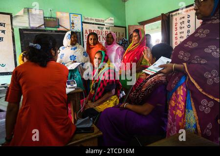 Nabin Nagar, ein Dorf an der Grenze zwischen Indien und Bangladesch, ist schlecht verbunden und isoliert von der Hauptstadt Tehatta, Indien. Deshalb wurde von der Regierung des Bundesstaates Westbengalen ein Lager eingerichtet, in dem die Dorfbewohner Medikamente verteilen konnten, nachdem sie Aadhaar-Karten durch einen medizinischen Offizier gezeigt hatten und mit Hilfe von asha-Arbeitern kostenlose Untersuchungen zur Blutdruckkontrolle an der Nabin Nagar-Grundschule durchgeführt hatten. An diesem Tag kommen alle armen Dorfbewohner, von den Ältesten bis zu den Schülern, zu einer kostenlosen medizinischen Untersuchung in Nabin Nagar, Westbengalen, Indien. Stockfoto