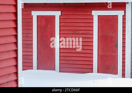 Schnee vor dem Holzlager mit Türen Stockfoto