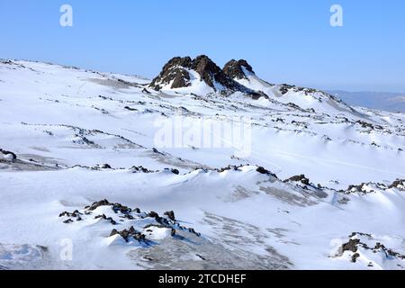 Annäherung an vulkanische Felsen, schneebedeckt mit „I Due Pizzi“ oder „Frati PII“ Hornitos am Berg des Ätna Nordostkraters, Sizilien, Italien (2) Stockfoto
