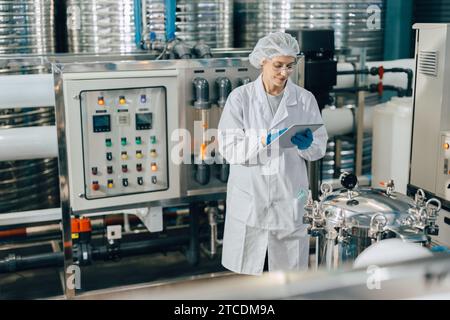 Hygienepersonal in der Lebensmittel- und Getränkefabrik. Arbeitende Frauen in der Wasserkraftwerksindustrie Qualitätskontrolle. Stockfoto