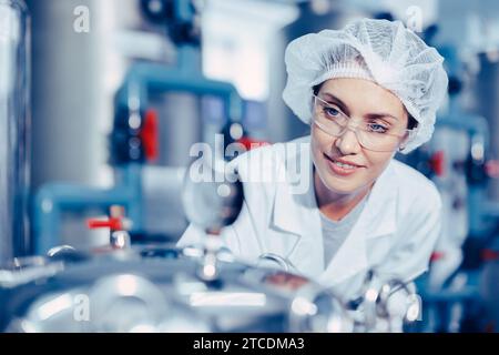 Arbeitnehmerinnen in Trinkwasseranlagen saubere Hygiene einheitliches Kontrolldruckmesser Wasserreinheitsverfahren. Stockfoto