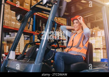 Glückliche junge asiatische Arbeiterin arbeitet in der Hafenfracht-Logistik-Transportindustrie Genießen Sie lächelnde Arbeit arbeiten Gabelstaplerfahrer betreiben. Stockfoto