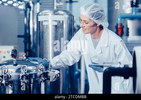 Hygienepersonal in der Lebensmittel- und Getränkefabrik. Arbeitende Frauen in der Wasserkraftwerksindustrie Qualitätskontrolle. Stockfoto