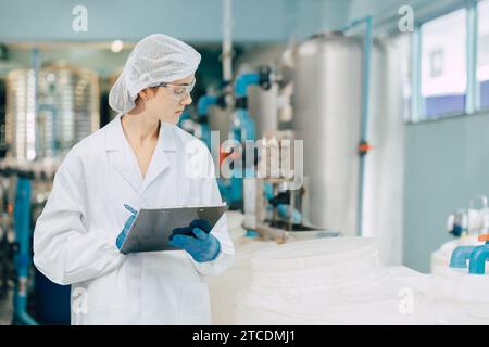 Hygienepersonal in der Lebensmittel- und Getränkefabrik. Arbeitende Frauen in der Wasserkraftwerksindustrie Qualitätskontrolle. Stockfoto