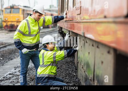 Das Ingenieurteam wartet den alten defekten Dieselzugpark im Bahndepot-Team, das mit Sicherheitsanzügen arbeitet. Stockfoto